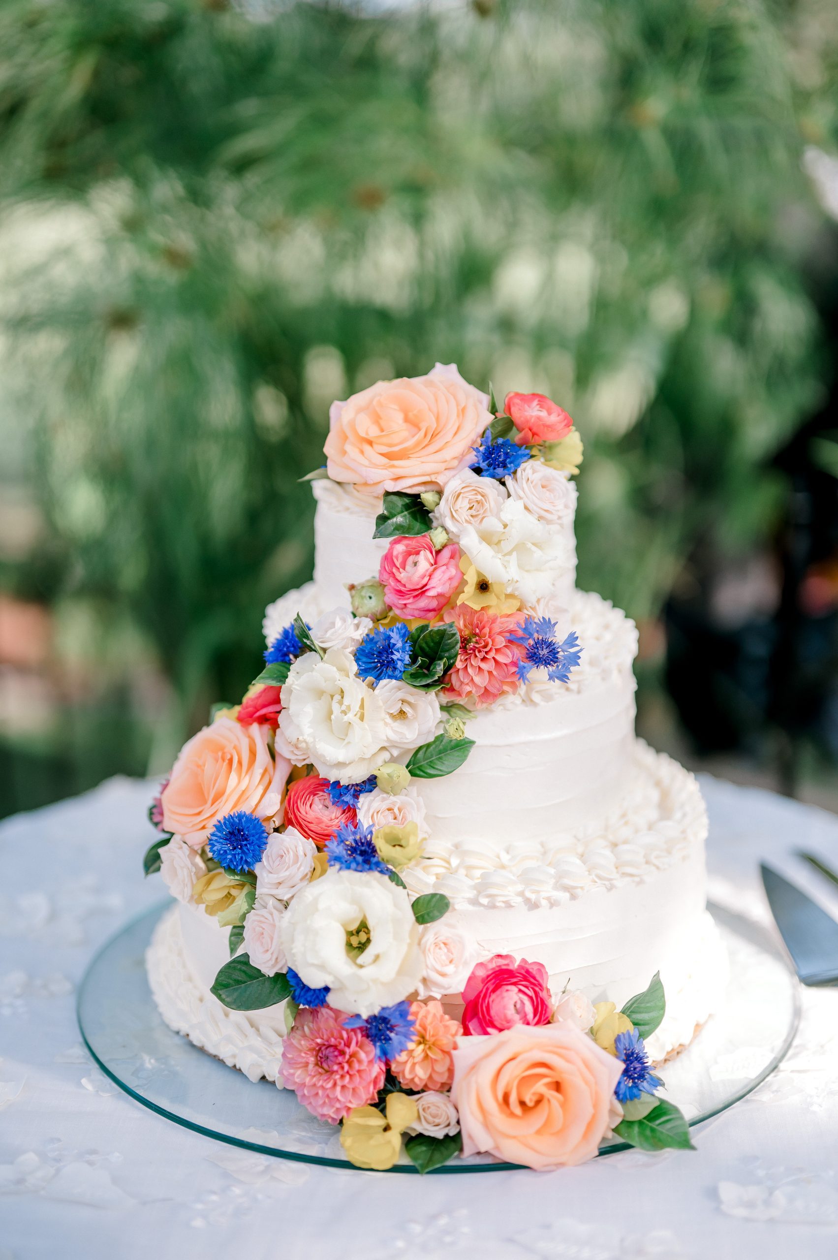 white wedding cake bright colorful floral cascade