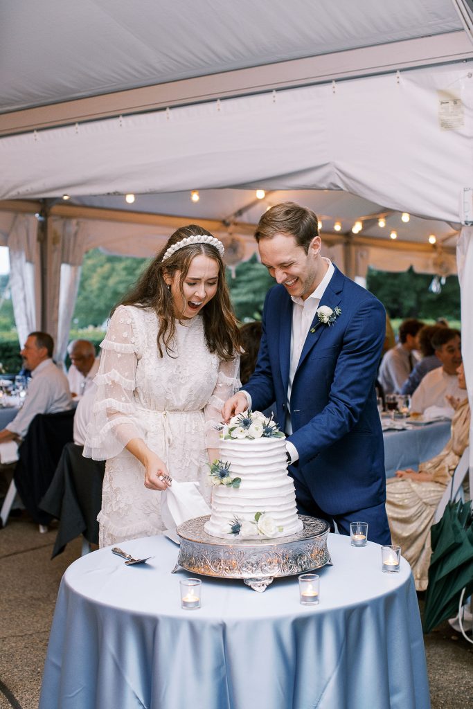 bride and groom cake cutting cool toned summer wedding reception
