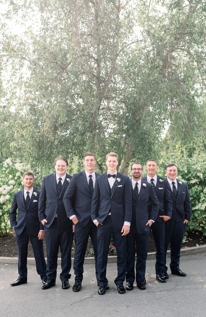 classic groom and groomsmen in black tuxedoes outdoor wedding portrait 