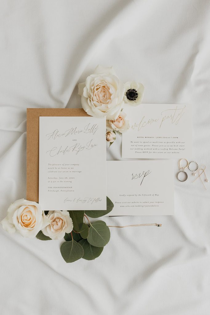modern wedding stationery suite and wedding bands with floral accents