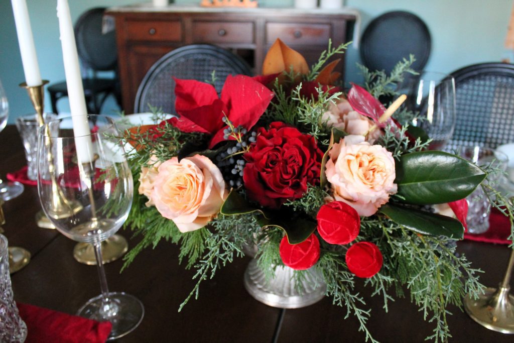 winter greenery with red and peach flowers Christmas floral design centerpiece